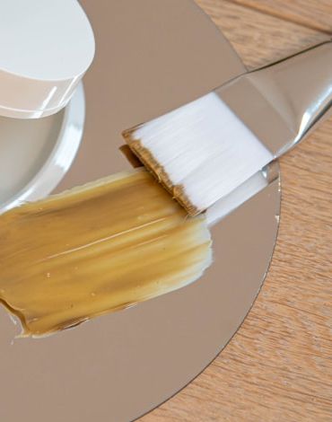 Brochazo de mascarilla de arcilla aplicándose sobre un espejo